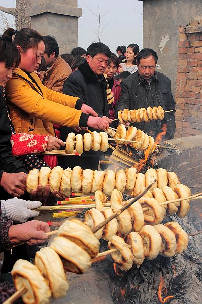 2013年3月16日，山东省茌平县韩屯镇罗屯村西北的鲁义姑庙会上，民众烤烧饼祈福求子。 (7).jpg